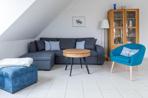 - un salon avec un canapé, une table et une chaise dans l'établissement Haus Jenny Wohnung H 5a, à Redewisch