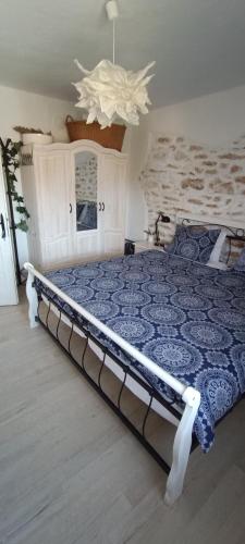a bedroom with a bed with a blue comforter at House Albena in Durankulak