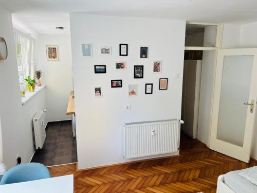 Cette chambre est dotée d'un mur blanc avec des photos. dans l'établissement Paula’s cosy place in the center of Ljubljana, à Ljubljana