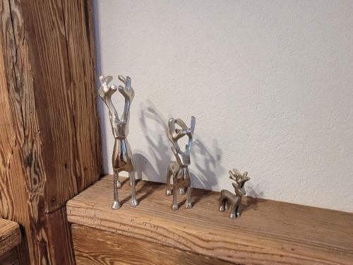 three metal statues sitting on top of a wooden shelf at Tirol Chalet Brixen in Brixen im Thale