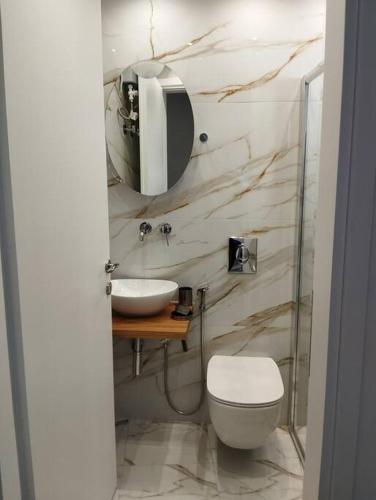 クサンティにあるKentrikon Guest Houseの洗面台、トイレ、鏡のあるバスルーム