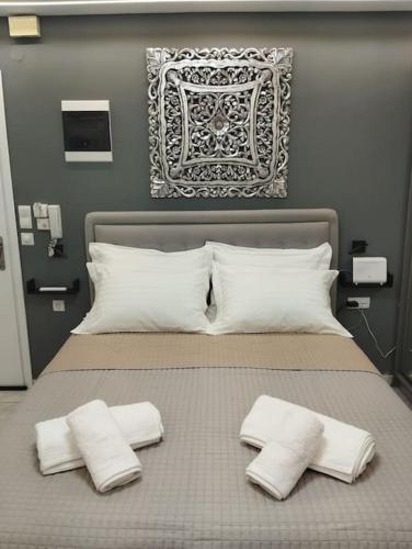 Una cama con dos almohadas blancas encima. en Kentrikon Guest House en Xanthi