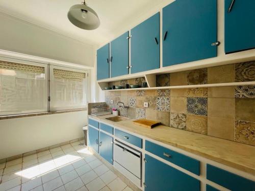 une cuisine avec des placards bleus et un comptoir dans l'établissement LX Factory Lisboa Apartament, à Lisbonne