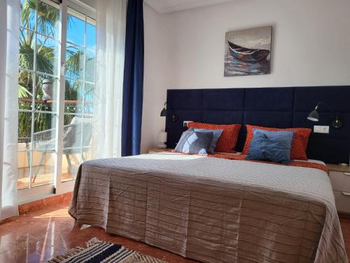 a bedroom with a large bed with a large window at King`s Apartaments in San Javier