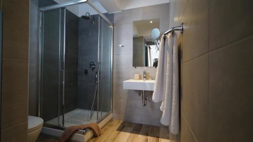 a bathroom with a shower and a sink and a toilet at Olympus Thalassea Hotel in Paralia Katerinis