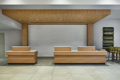 un vestíbulo con escritorios y sillas de madera en un edificio en Hilton Garden Inn Tewksbury Andover, en Tewksbury