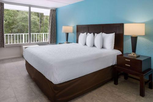 a bedroom with a large bed and a large window at Travelodge by Wyndham Kingsland GA in Kingsland