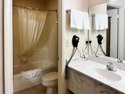 ein Badezimmer mit einem Waschbecken, einem WC und einem Spiegel in der Unterkunft Motel 6 Abbeville, AL in Abbeville