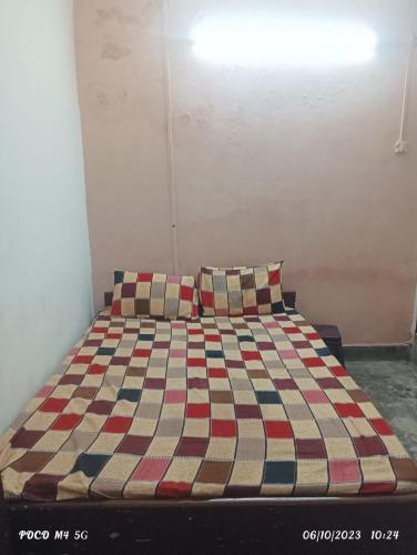 a bed with two pillows on it in a room at NAVRANG DELHI BACKPACKER in New Delhi