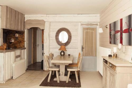 eine Küche mit einem Tisch mit Stühlen und einem Spiegel in der Unterkunft Appartement Tignes Val-Claret // 6 Personnes in Tignes