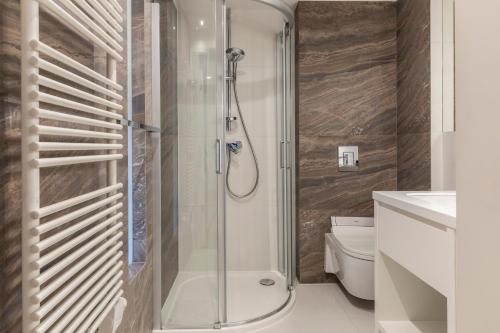 uma casa de banho com um chuveiro e um WC. em MOUNTAIN BASE Apartament Bellissimo em Zakopane