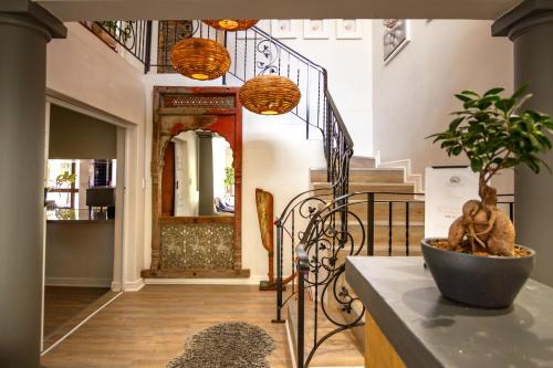 a hallway with a staircase with a potted plant at Chateau de Marine Boutique Hotel in Struisbaai