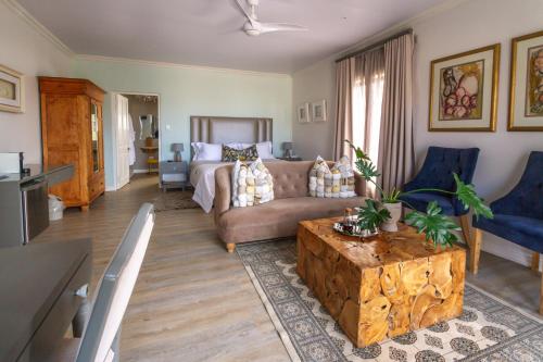 een woonkamer met een bank en een tafel bij Chateau de Marine Boutique Hotel & Wellness in Struisbaai