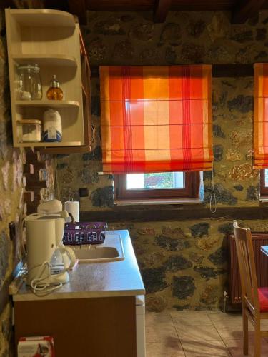 a kitchen with aicolored window and a stove top oven at Suites Mouses in Palaios Agios Athanasios