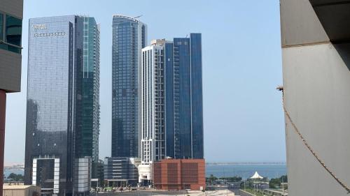 a group of tall buildings in a city at Sharing motel rooms in Abu Dhabi