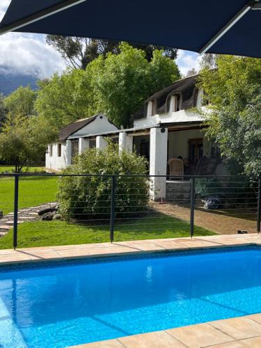 a house with a swimming pool in front of a house at Welbedacht Game & Nature Reserve in Tulbagh