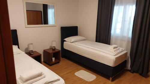 a small bedroom with two beds and a mirror at Holiday Retreat Apartment - Zadar in Zadar