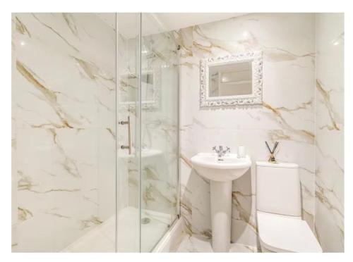 y baño blanco con lavabo y ducha. en 8 bedroom Annexe at Moulton Grange, en Northampton