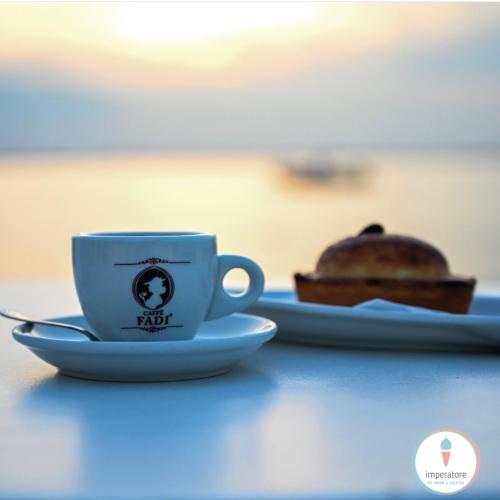 een kop koffie en een stuk taart op een tafel bij B&B Felix - Porto Cesareo in Porto Cesareo