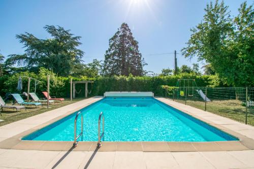 einen Pool im Garten mit Stühlen und Bäumen in der Unterkunft La Charronnière: La P’tite Boulangerie in Chaunay