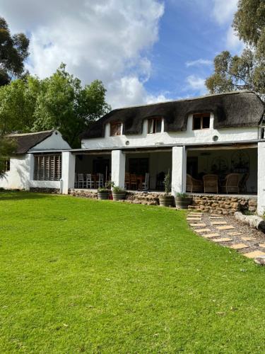 a white house with a lawn in front of it at Welbedacht Game & Nature Reserve in Tulbagh