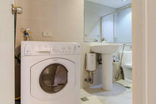 - un lave-linge dans la salle de bains pourvue d'un lavabo dans l'établissement The Gramercy Residences, à Manille