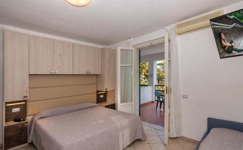 Schlafzimmer mit einem Bett und einer Tür zu einem Balkon in der Unterkunft Hotel Eura in Marina di Massa