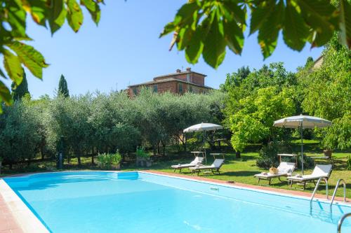 a swimming pool with chairs and umbrellas at Villa Vignacce - Boutique Country Resort in Bettolle