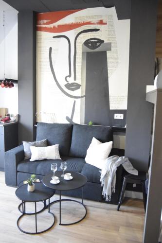 - un salon avec un canapé bleu et 2 tables dans l'établissement RESIDENCIAL ALCOY Apartahotel, à Alcoy