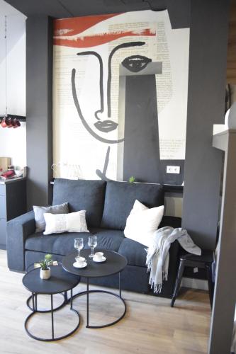 a living room with a blue couch and two tables at Residencial Alcoy in Alcoy