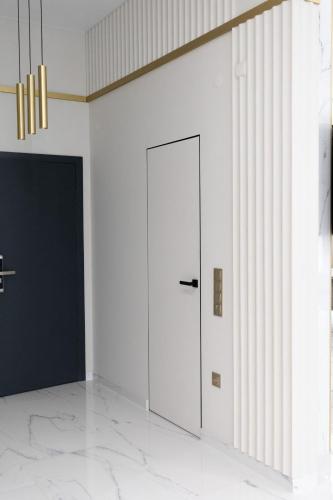 a door in a white room with a wall at Villa Grey Hotel in Duliby