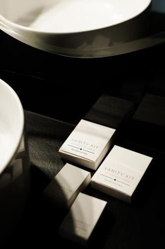 three white cards sitting on a table in a room at Villa Grey Hotel in Duliby