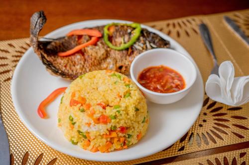 Stay Simple Lodge في لوساكا: طبق من الطعام مع الرز والخضار على الطاولة
