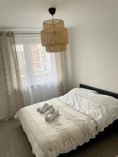 a bed with two towels on it with a window at Białe Noce Apartament in Biała Podlaska
