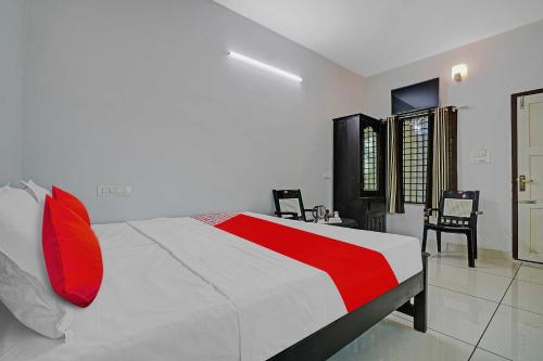 una camera da letto con un grande letto con cuscini rossi di OYO Flagship Hornbill Residency a Alleppey