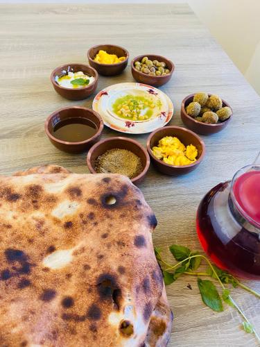 a table with plates of food and bowls of condiments at Petra NefNaf Hostel in Wadi Musa