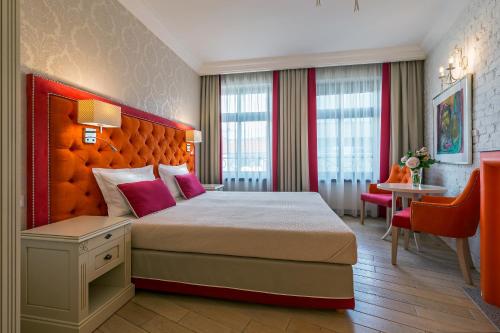 a hotel room with a large bed and a table at SleepWalker Boutique Suites in Wrocław