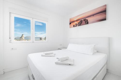 ベニドルムにあるVeracruz 18-A Deluxe Apartment Levante Beachの白いベッドルーム(大きな白いベッド1台、窓2つ付)