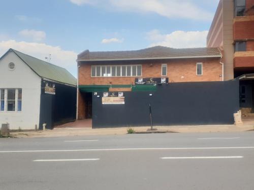a building on the side of a street with a fence at Camp Inn BnB in Pietermaritzburg