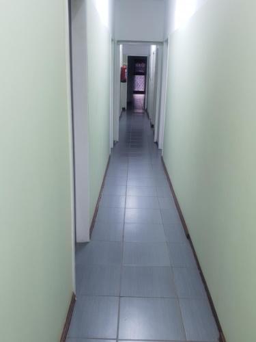 a long hallway with white walls and a long tile floor at Camp Inn BnB in Pietermaritzburg