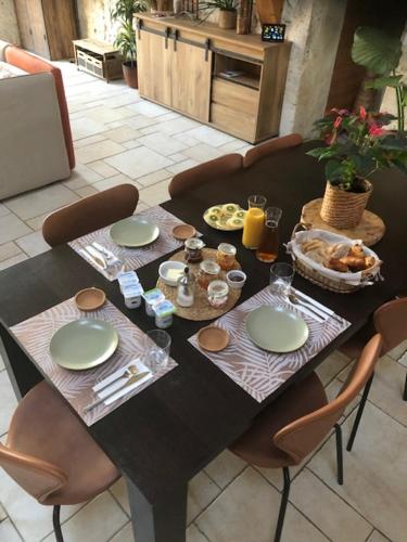 - une table noire avec des chaises et de la nourriture dans l'établissement Chambre d'hôtes La Détente - Domaine la Rose des vents, à Castelnau-sur-lʼAuvignon