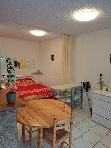 PeyrestortesにあるStudio proche de Perpignanのベッド、テーブル、テーブルが備わる客室です。