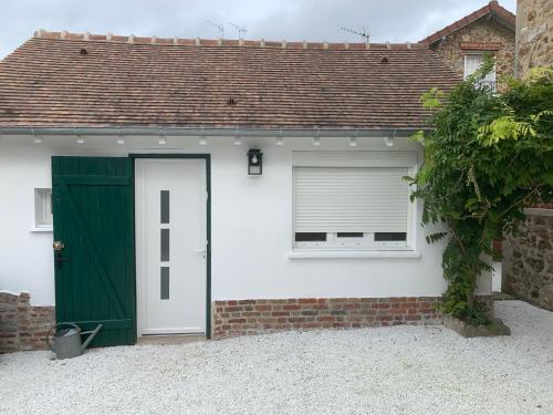 a white house with a green door and a window at Proche Paris et Disney avec piscine-calme absolu, terrasse et parking privé in Vaires-sur-Marne