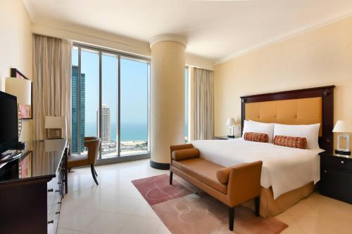 a bedroom with a bed and a view of the ocean at Marriott Marquis City Center Doha Hotel in Doha