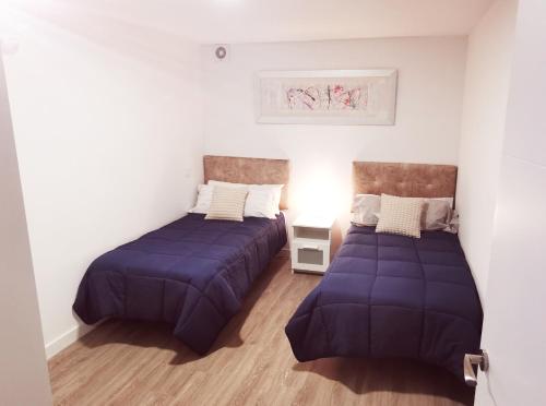 2 camas en una habitación con sábanas moradas en Piso de lujo 2 habitaciones, en Las Rozas de Madrid