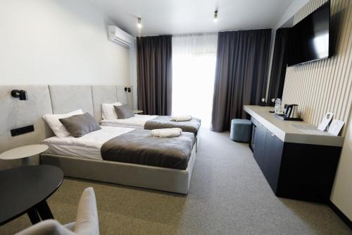 um quarto de hotel com uma cama e um lavatório em Villa Grey Hotel em Duliby