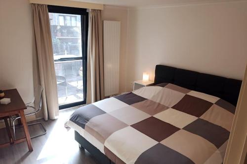 um quarto com uma cama e uma grande janela em LodgeRivierenhof em Antuérpia