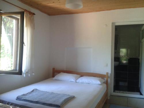 Bett in einem Zimmer mit einem Fenster und einem Bett sidx sidx sidx sidx in der Unterkunft Cennet Pansiyon in Kaleucagız