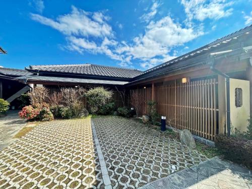 een huis met een grindoprit ervoor bij 湯布院 旅館 やまなみ Ryokan YAMANAMI in Yufu