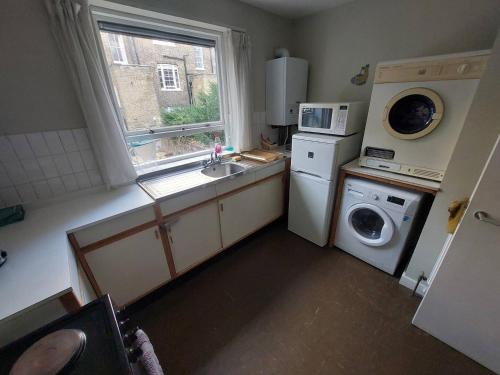 a small kitchen with a sink and a washing machine at Bloomsbury 2 room flat in London